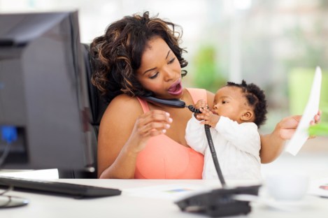 busy african businesswoman with baby girl working